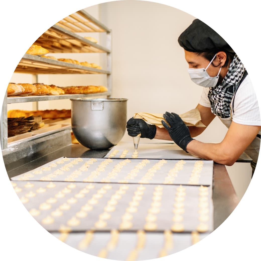 A baker piping pastries in a bakery